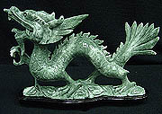 JADE SINGLE DRAGON (HJ062E)
This Dragon is carved from one solid piece of jade. It comes with a rosewood base. Very detailed carving. 
SIZE: L: 14 in, W: 3 in, H: 10 in